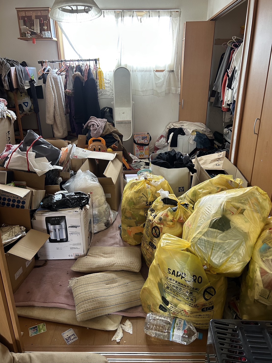 札幌市のゴミ屋敷整理作業前 室内に散乱した不用品と黄色ゴミ袋